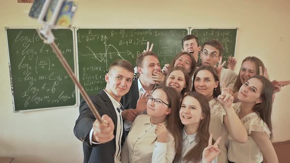 Students in the Classroom Amusingly Do Selfie on the Background of the School Board
