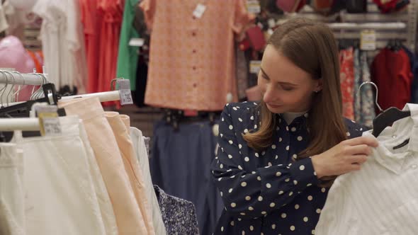 Woman Chooses Clothes in a Shopping Center or Clothing Store