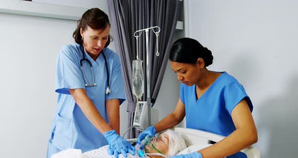 Doctor and nurse treating senior patient in ward