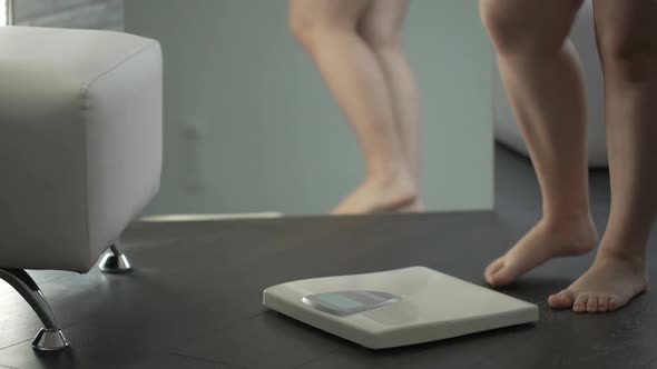 Overweight Female Hesitating Before Stepping on Scales to Check Weight, Fear