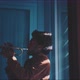 A trumpeter playing in a dark room with rays of light filtering through the shutters - VideoHive Item for Sale