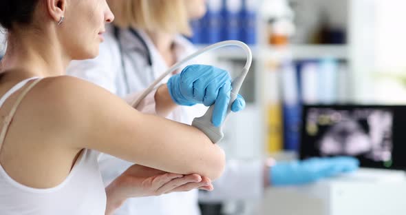 Doctor Conducts Ultrasound Examination of Patient Elbow in Clinic