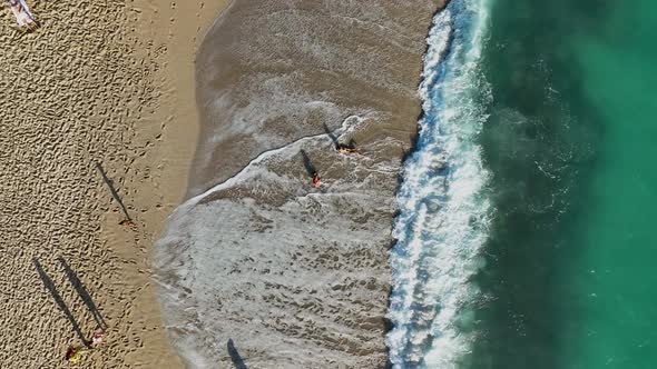 A young girl happily fights with the waves aerial view 4 K