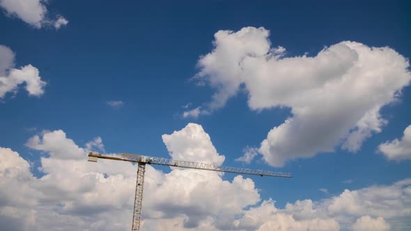 Tower Crane on Construction Site, Moving Clouds in Blue Sky Sunny Summer Day alt