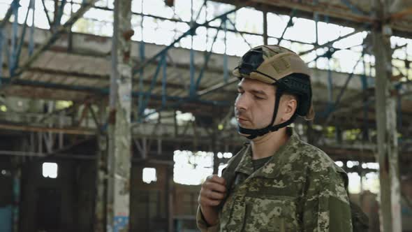 Soldier in Helmet Walking on Abandoned Steel Plant