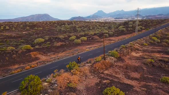 Aerial View of Cyclist Rider Traveling Up a Desert Road