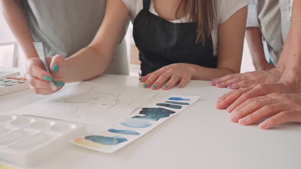 Female Hand Drawing in Album with Watercolor Paints and Paintbrush