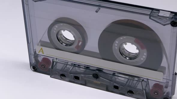 Vintage Transparent Audio Cassette Rotates on White Background