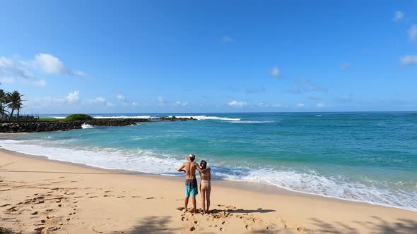 Surfers Stand On A Tropical Beach