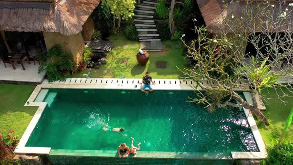 Happy Family Swims and Relaxes in a Luxurious Infinity Pool in a Tropical Paradise in Ubud, Bali