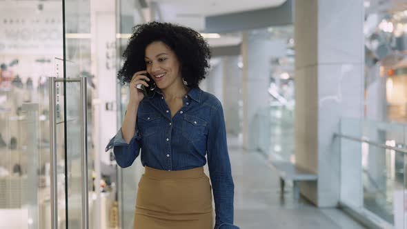 Smiling African American Woman Talking on the Phone in the Mall