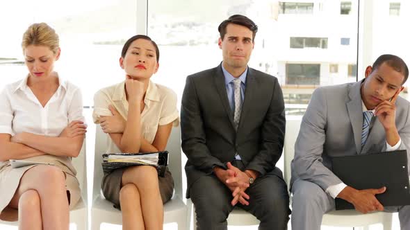 Business people waiting for an interview in a row