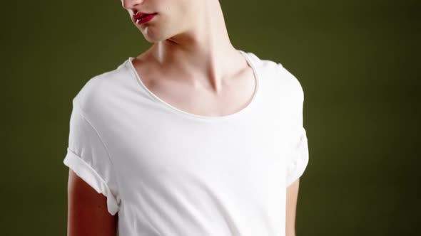 Androgynous man posing against green background