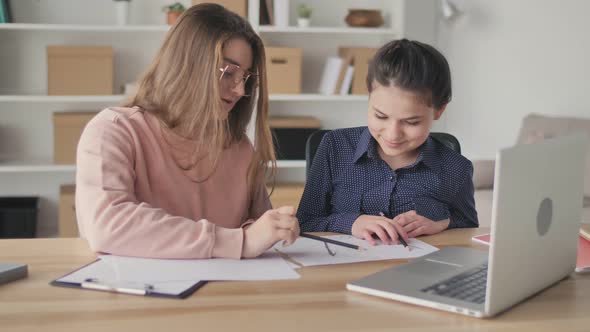 Young Womanmentor Helping Teenage Girl Study Do Homework School Homeschooling