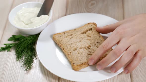 Woman Spreads Curd Cheese on Cereal Bread