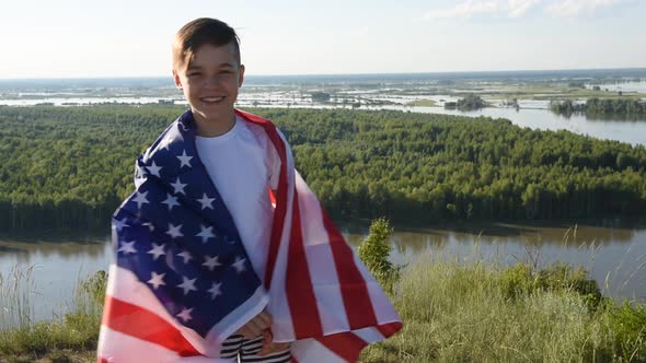 Blonde Boy Waving National USA Flag Outdoors Over Blue Sky at the River Bank