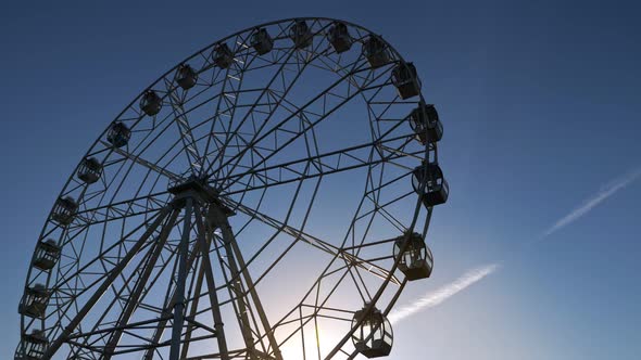Large Operating Metal Ferris Wheel Ride Turns in Local Park