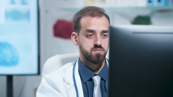 Close Up Shot of Tired and Exhausted Doctor Working on the Computer