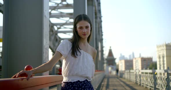 Sensual Young Woman Is Walking Back on Road on Railway Bridge in City in Summer