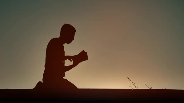 Man Reading Religious Book at Evening