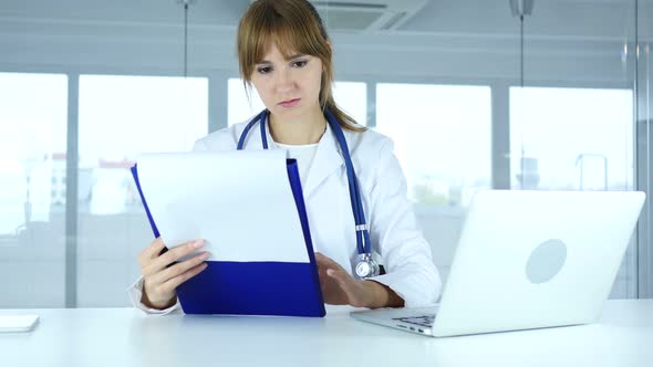 Female Doctor Reading Medical Reports of Patient