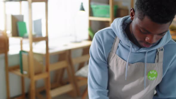 Black Man Putting Stickers on Containers with Healthy Food