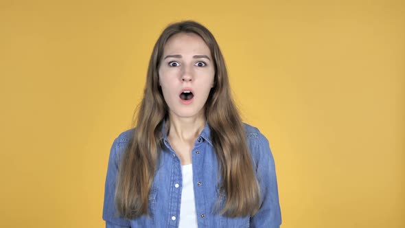 Surprised Pretty Woman in Shock Isolated on Yellow Background Wondering