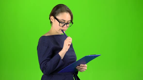 Accountant Records the Data in a Paper Tablet. Green Screen