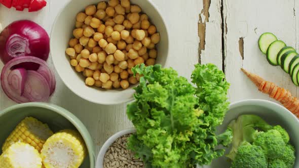 Video of bowls of fresh vegetables over white rustic background