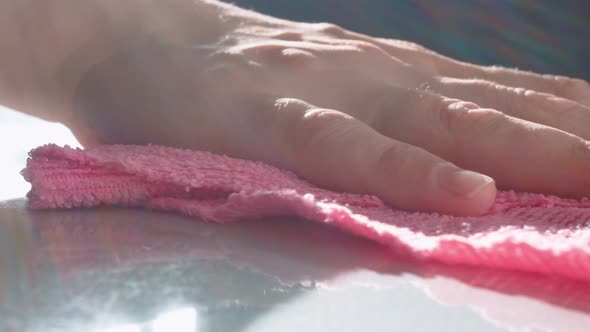 In the Reflection of the Table Surface One Can See the Hand and Part of the Woman's Hand Wiping the