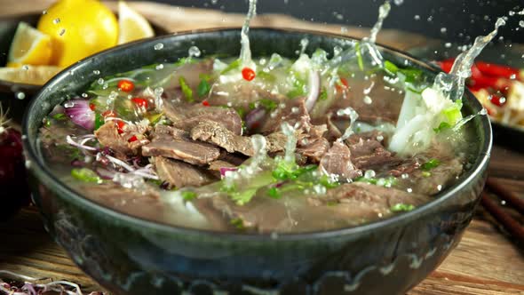 Super Slow Motion Detail Shot of Sliced Beef Falling Into Pho Soup at 1000 Fps