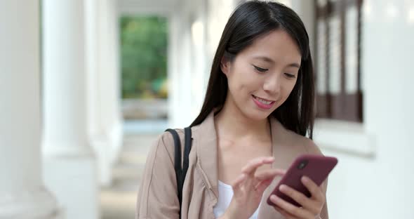 Asian woman sending sms on mobile phone