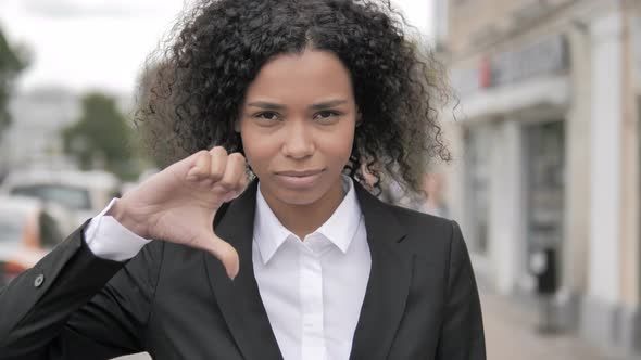 Thumbs Down by African Businesswoman Standing Outdoor by Road