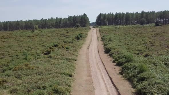 Drone gliding along a dirt road in Woodbury, Devon in England.