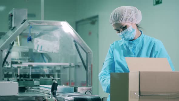 Female Pharmacologist Packing Medicines Into a Box