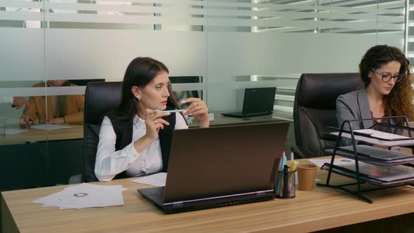 Stressed woman spinning the chair while sitting at her working place in office.