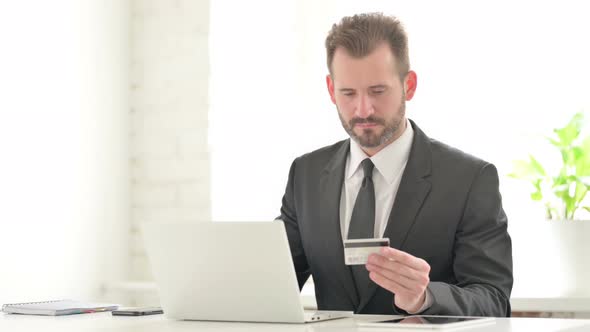 Young Businessman Making Successful Online Payment on Laptop