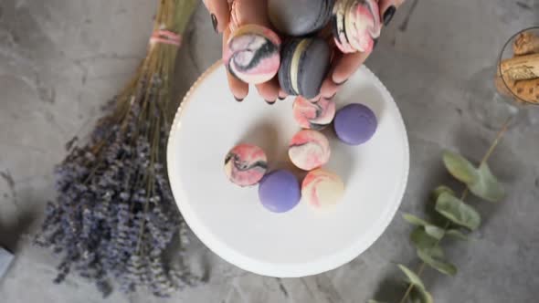 Woman Stretching Out Macaroons in the Hands