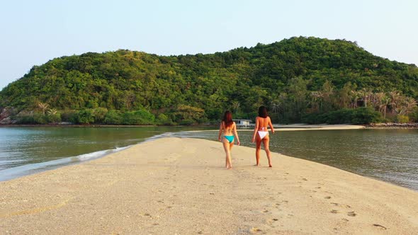 Girls posing on tropical shore beach vacation by blue ocean with white sand background of Thailand n