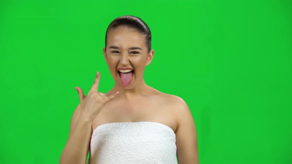 Natural Female Making a Rock Gesture, Enjoying Life and Laughing, Isolated on Green Screen at Studio