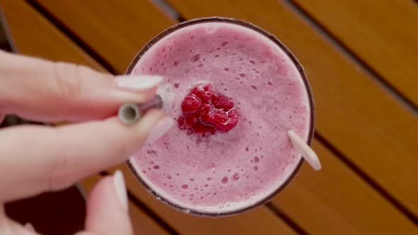 Vegan Cocktail with Raspberries in a Glass on a Wooden Table in Cafe