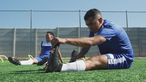 Soccer players stretching on field