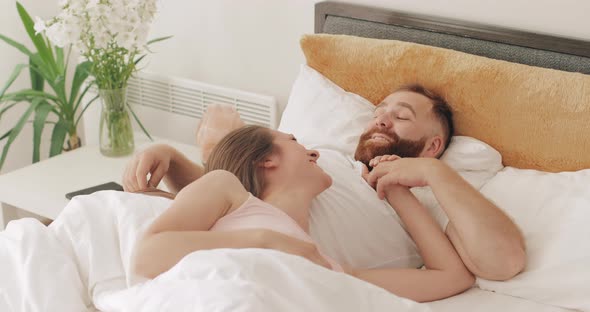 Portrait of Cute Cheerful Couple Lying on Bed in Early Morning, Talking and Smiling, Beautiful Woman