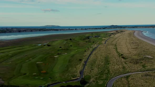 . Drone tracking left, over the Irish landscape at golden hour.