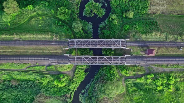 Railway Bridge Among Green Meadows Over a Small River in the Countryside