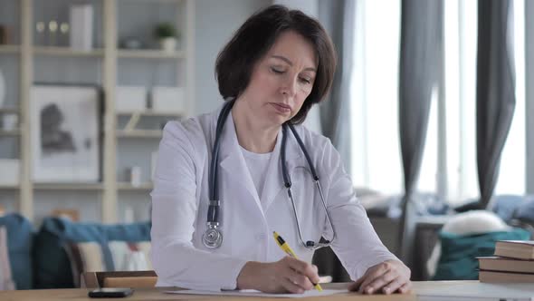 Old Lady Doctor Writing Medical Report Paperwork