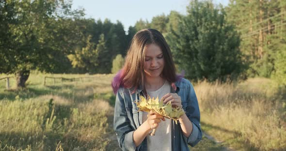 Young Beautiful Girl with Ripe Sunflower in Hands