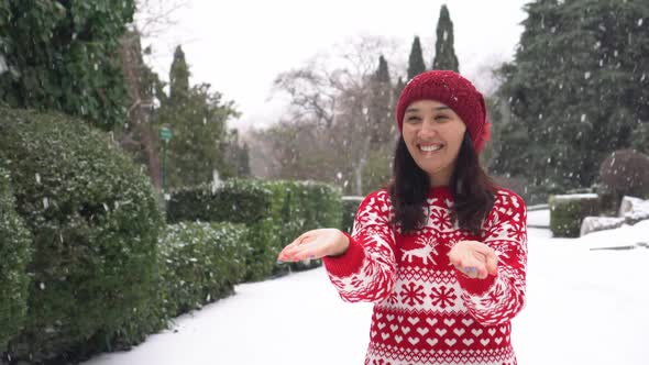 Happy Young Lady Lady Catches Snow with Her Hands