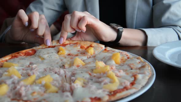 Female Hands Take a Slice of Pizza