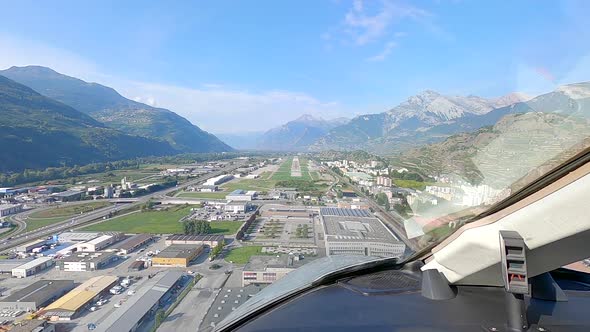 Pilot viewpoint from cockpit, aircraft landing at mountain airport POV